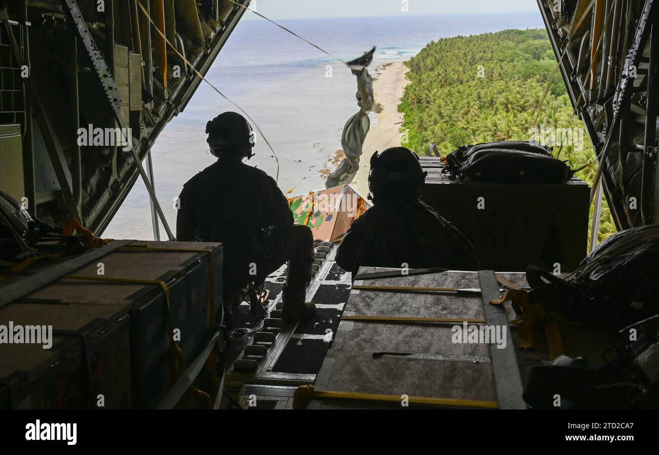 NAMA, Îles Mortlock supérieures, États fédérés de Micronésie. 04 décembre 2023. Les maîtres de chargement de l'armée de l'air américaine SSgt. Matthew Muravez et l'aviateur principal Megan Irvin, larguent des paquets humanitaires en parachute sur une lagune depuis un avion C-130J Super Hercules de l'US Air Force, lors de l'opération Christmas Drop, le 4 décembre 2023 à Nama, dans les îles orientales, en Micronésie. L’opération Christmas Drop est la plus ancienne mission humanitaire et de secours en cas de catastrophe qui fournit 71 000 livres de nourriture, de cadeaux et de fournitures pour aider les communautés insulaires éloignées du Pacifique Sud. Crédit : SRA Allison Martin/US Airforce photo/Alamy Li Banque D'Images