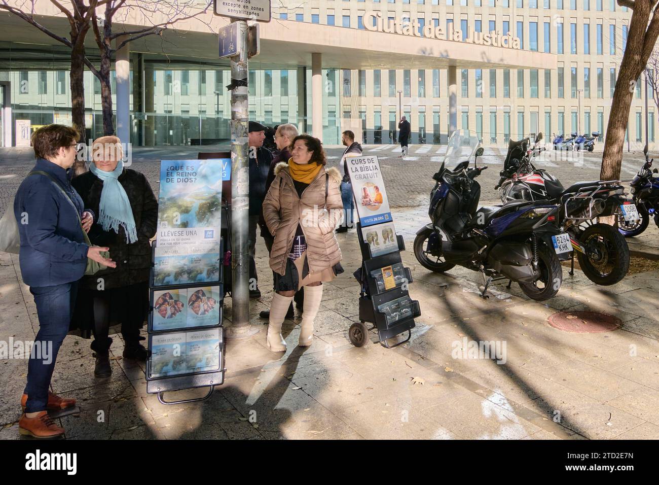 Barcelone - 15 décembre 2023 : groupe de personnes discutant dans une rue urbaine à côté d'une publicité religieuse dans la ville de Justice de Barcelone Espagne Banque D'Images