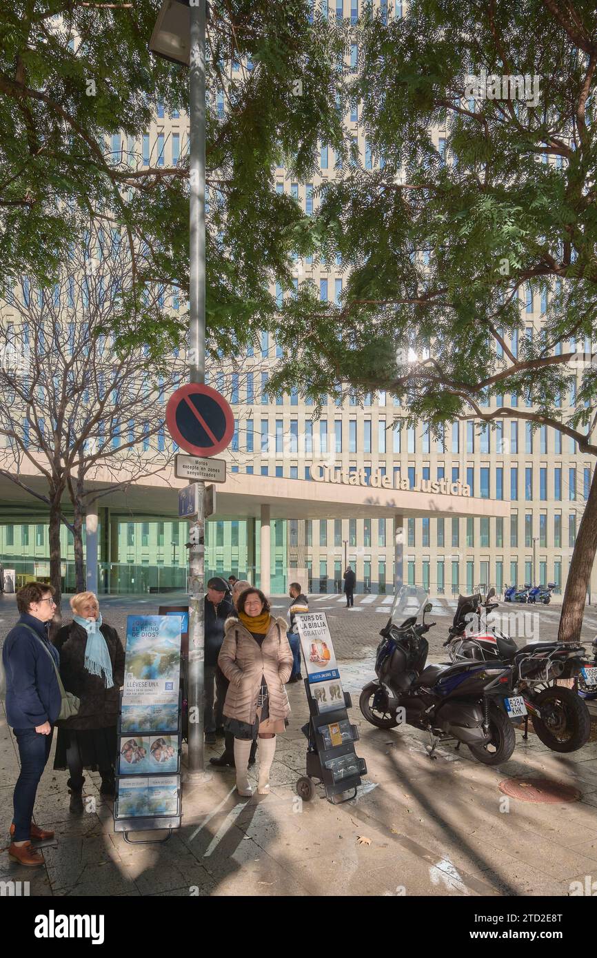 Barcelone - 15 décembre 2023 : groupe de personnes discutant dans une rue urbaine à côté d'une publicité religieuse dans la ville de Justice de Barcelone Espagne Banque D'Images