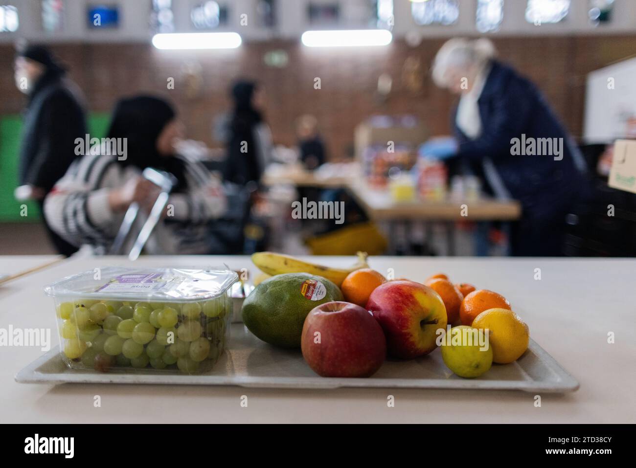 PRODUCTION - 15 décembre 2023, Rhénanie du Nord-Westphalie, Oberhausen : les personnes dans le besoin reçoivent de la nourriture de la banque alimentaire. Files d’attente devant les points de distribution des banques alimentaires, bénévoles à la limite de leurs capacités et demande toujours croissante de nourriture : l’aide à plus de 600 000 personnes dans le besoin en NRW atteint ses limites. Photo : Rolf Vennenbernd/dpa Banque D'Images