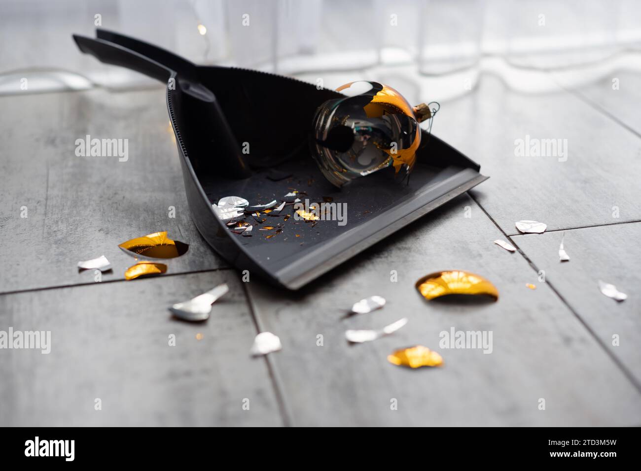 Boule de Noël dorée cassée sur la pelle sur le sol. Le concept de fin de vacances de Noël Banque D'Images