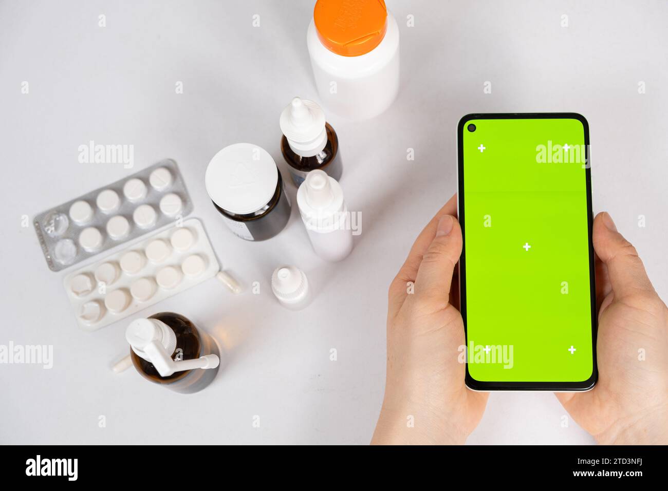 Écran vert chroma key smartphone dans les mains du patient ou du médecin et beaucoup de médicaments. Médicament, mode d'emploi. Banque D'Images
