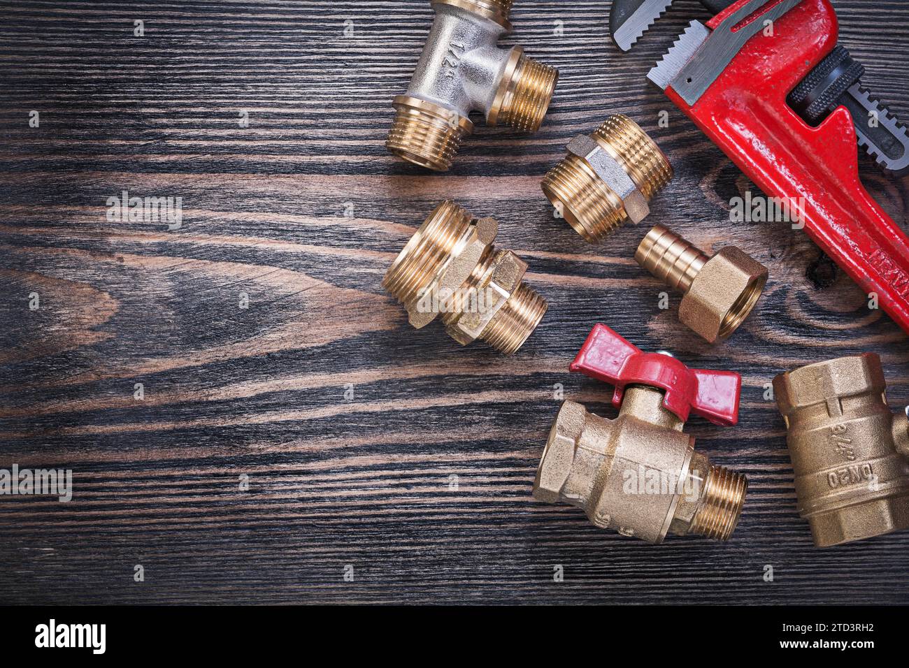 Assortiment de raccords réglables en laiton de clé singe valve d'eau sur le concept de plomberie de panneau de bois Banque D'Images