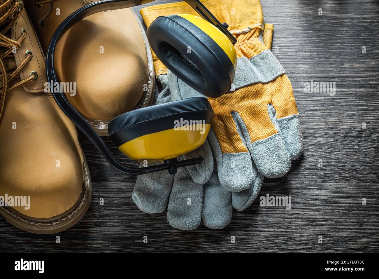 Gants de sécurité bottes de travail cache-oreilles sur planche de bois Banque D'Images