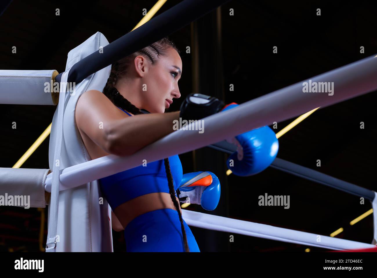 Puissante fille chargée se tient dans le coin de l'anneau et est prête à exploser dans le prochain tour. Le concept de lutte et de boxe. Supports mixtes Banque D'Images