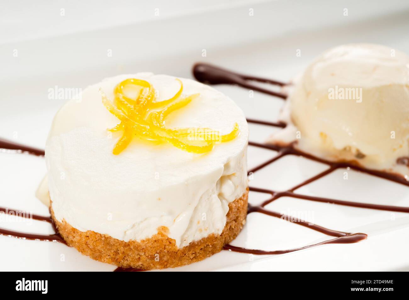 Dessert de mousse au citron très élégant servi avec zeste de citron sur le dessus et crème glacée à la vanille sur le côté, NOURRITURE PLUS DÉLICIEUSE SUR LE PORTFOLIO, photographie alimentaire Banque D'Images