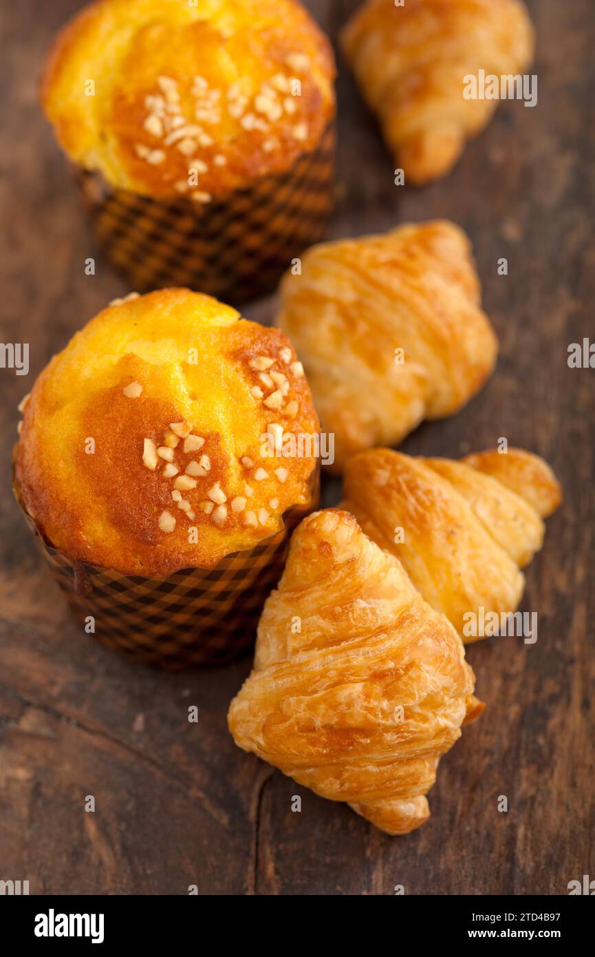 Muffin frais et croissant mignon sur une vieille table en bois Banque D'Images