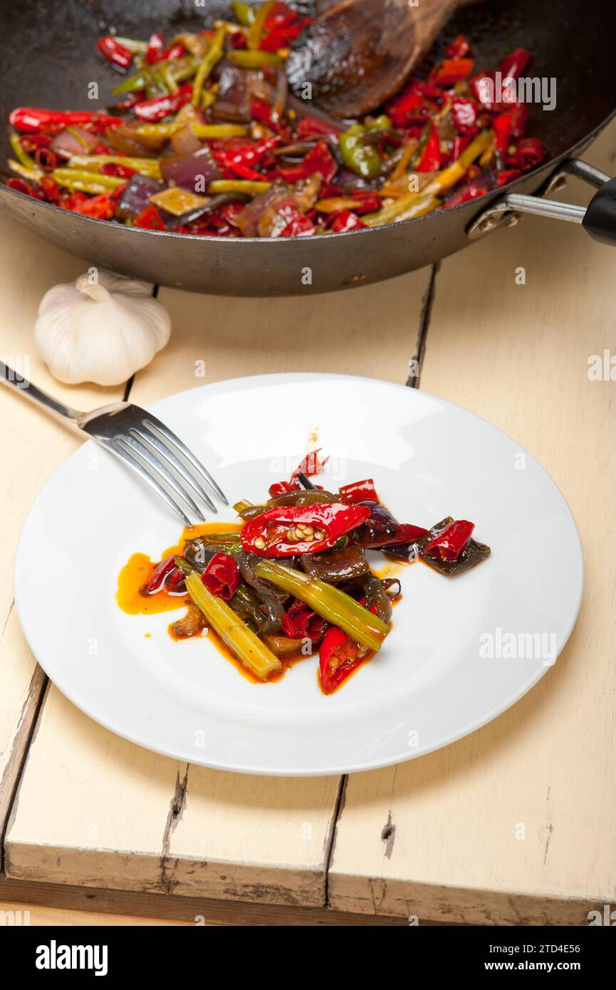 Piment frit et légumes sur une poêle wok en fer Banque D'Images