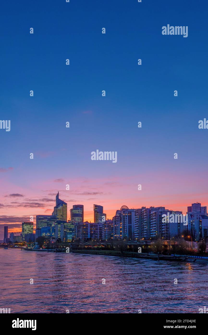 Vue lointaine des immeubles de bureaux modernes et des gratte-ciel au coucher du soleil sur une rive de la Seine dans le quartier des affaires de Paris la Défense, France Banque D'Images