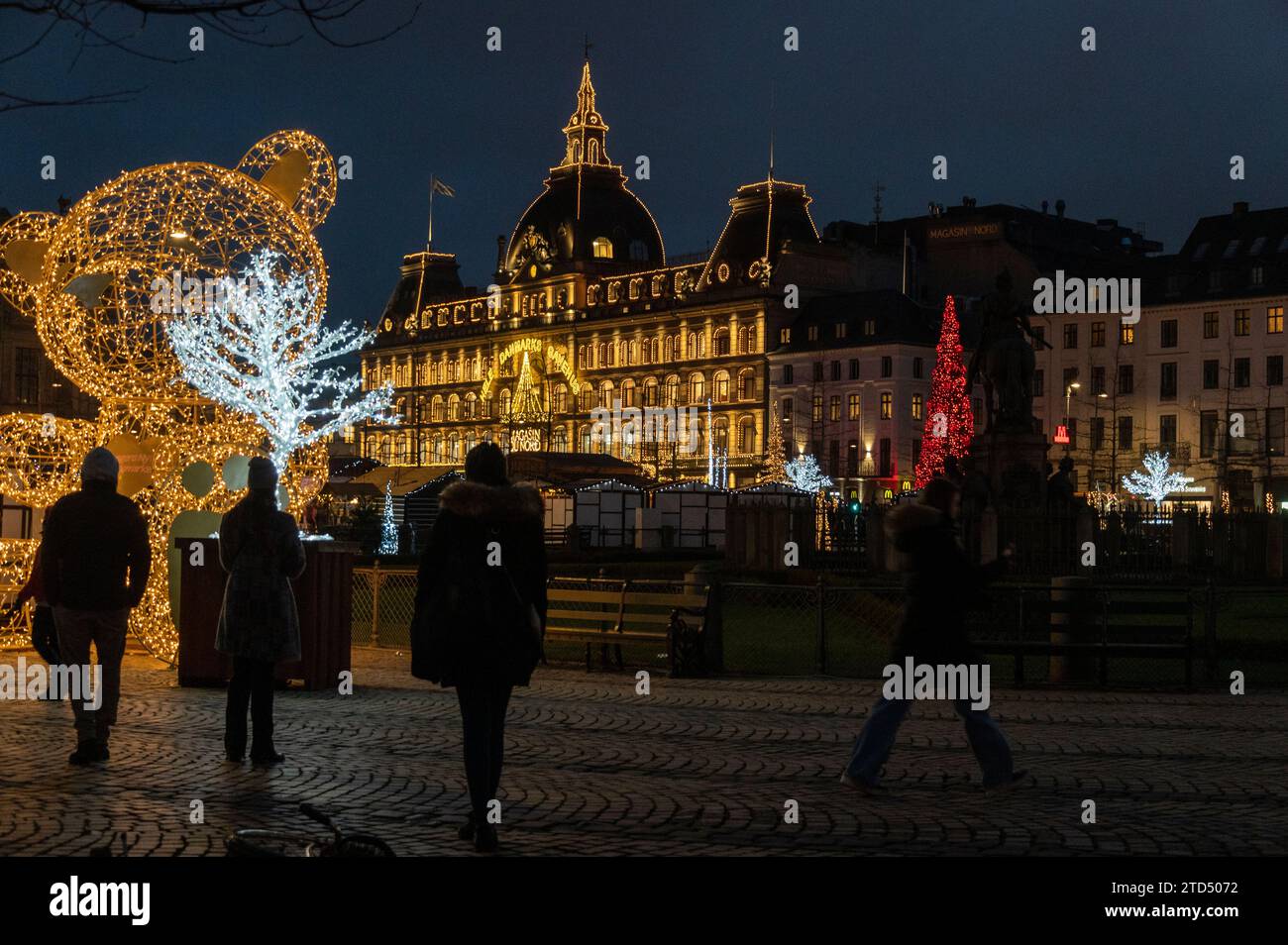 Une scène de shopping de Noël animée bordée de cabanes en bois allemandes traditionnelles importées de la région du Tyrol en Autriche, au Julemarked (mar de Noël Banque D'Images