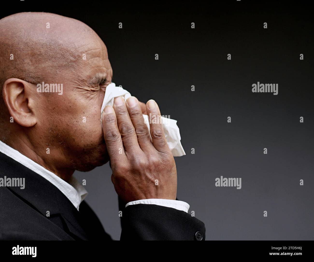 homme attrapant le rhume et la grippe homme soufflant le nez après avoir attrapé un rhume avec fond gris avec des gens photo stock Banque D'Images