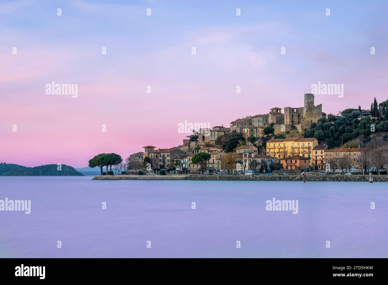 Village perché de Passignano reflété dans le lac Trasimeno, Ombrie, Italie Banque D'Images