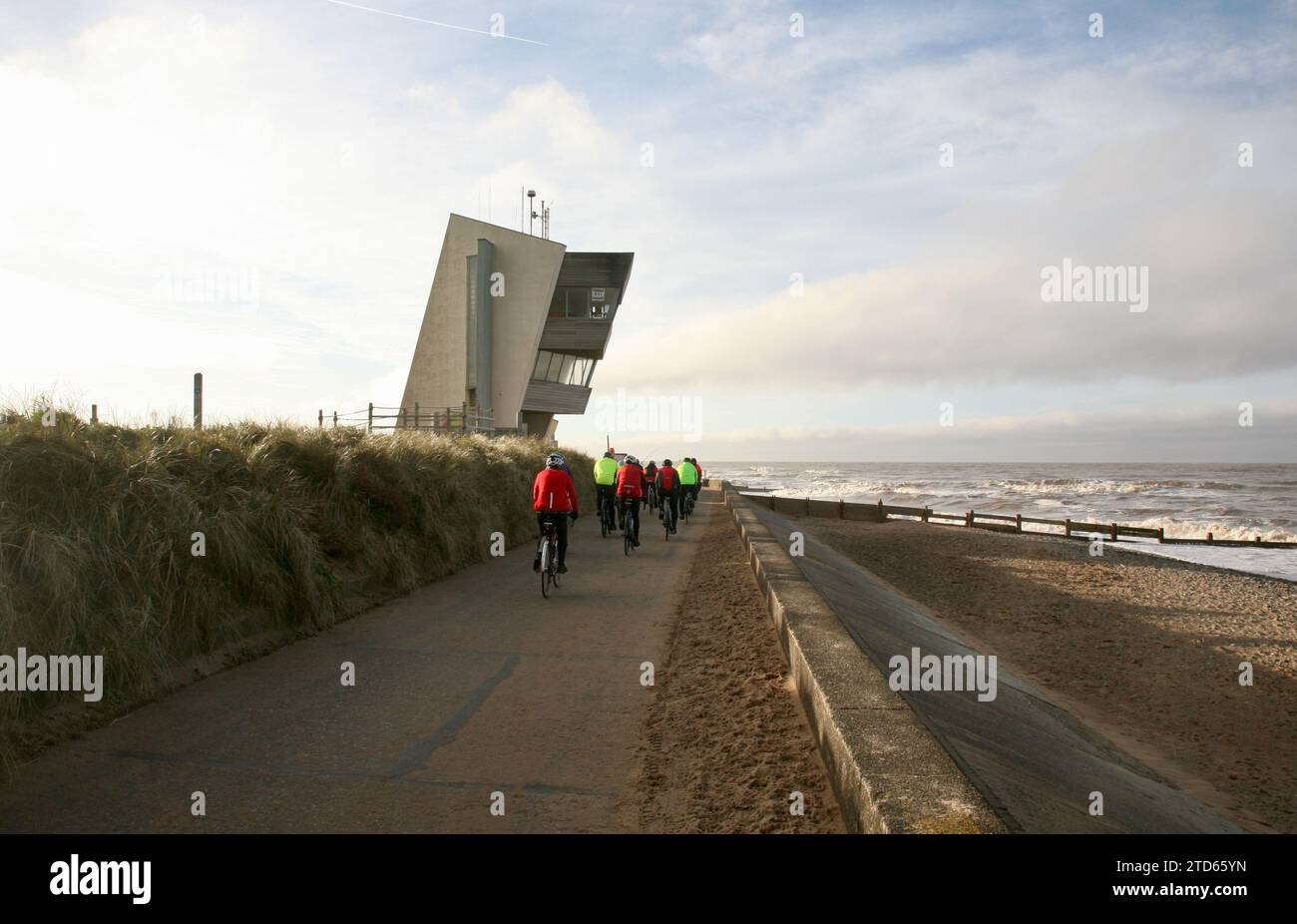 Un groupe de cyclistes court le long de la promenade extérieure, devant la tour d'observation de Rossall point, Fleetwood, Lancashire, Royaume-Uni, Europe Banque D'Images