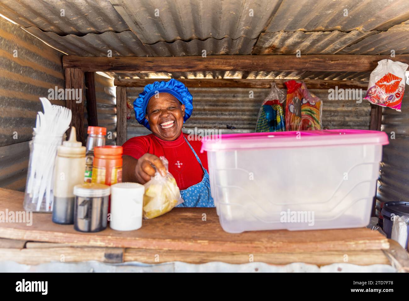 vendeur de rue dans une cabane, vendant à une jeune femme africaine, quelques frites chaudes Banque D'Images