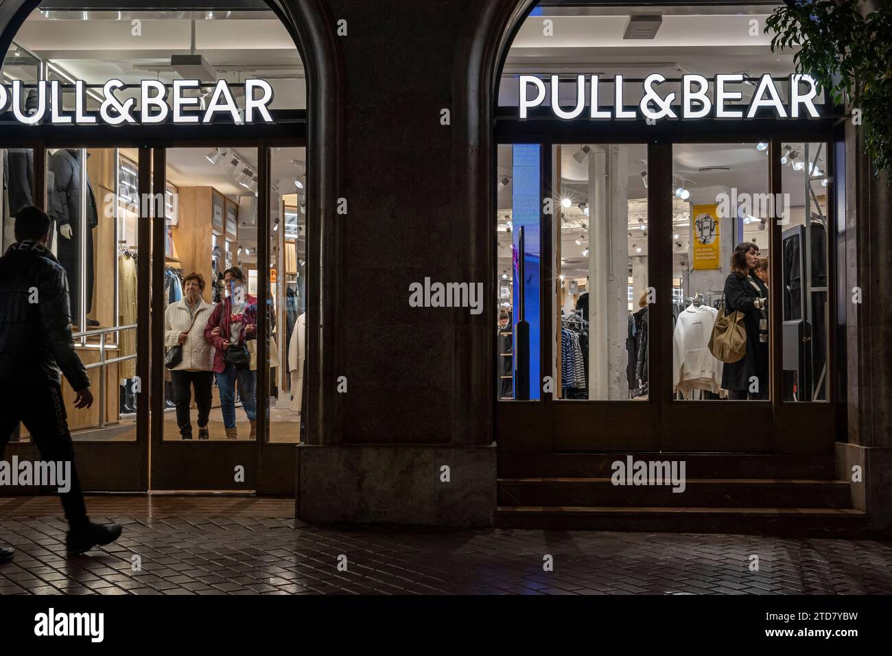 Palma de Majorque, Espagne ; décembre 12 2023 : façade principale d'un magasin vendant des articles de mode et des accessoires de la chaîne internationale Pull & Bear, la nuit. P Banque D'Images