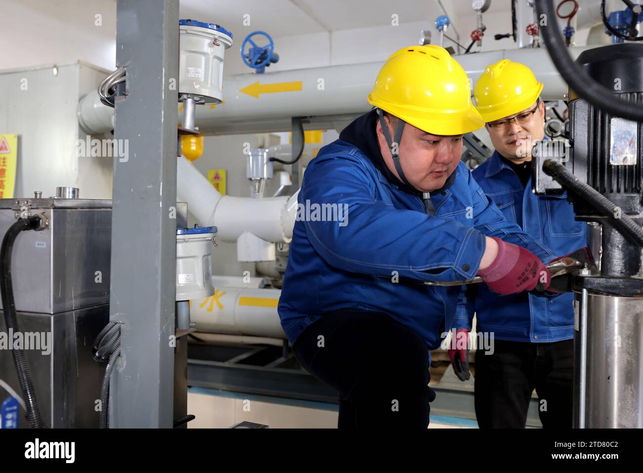 ZAOZHUANG, CHINE - 17 DÉCEMBRE 2023 - des membres du personnel vérifient l'équipement de chauffage à une station d'échange de chaleur dans la communauté de Wantai Garden dans la ville de Zaozhuang, Banque D'Images