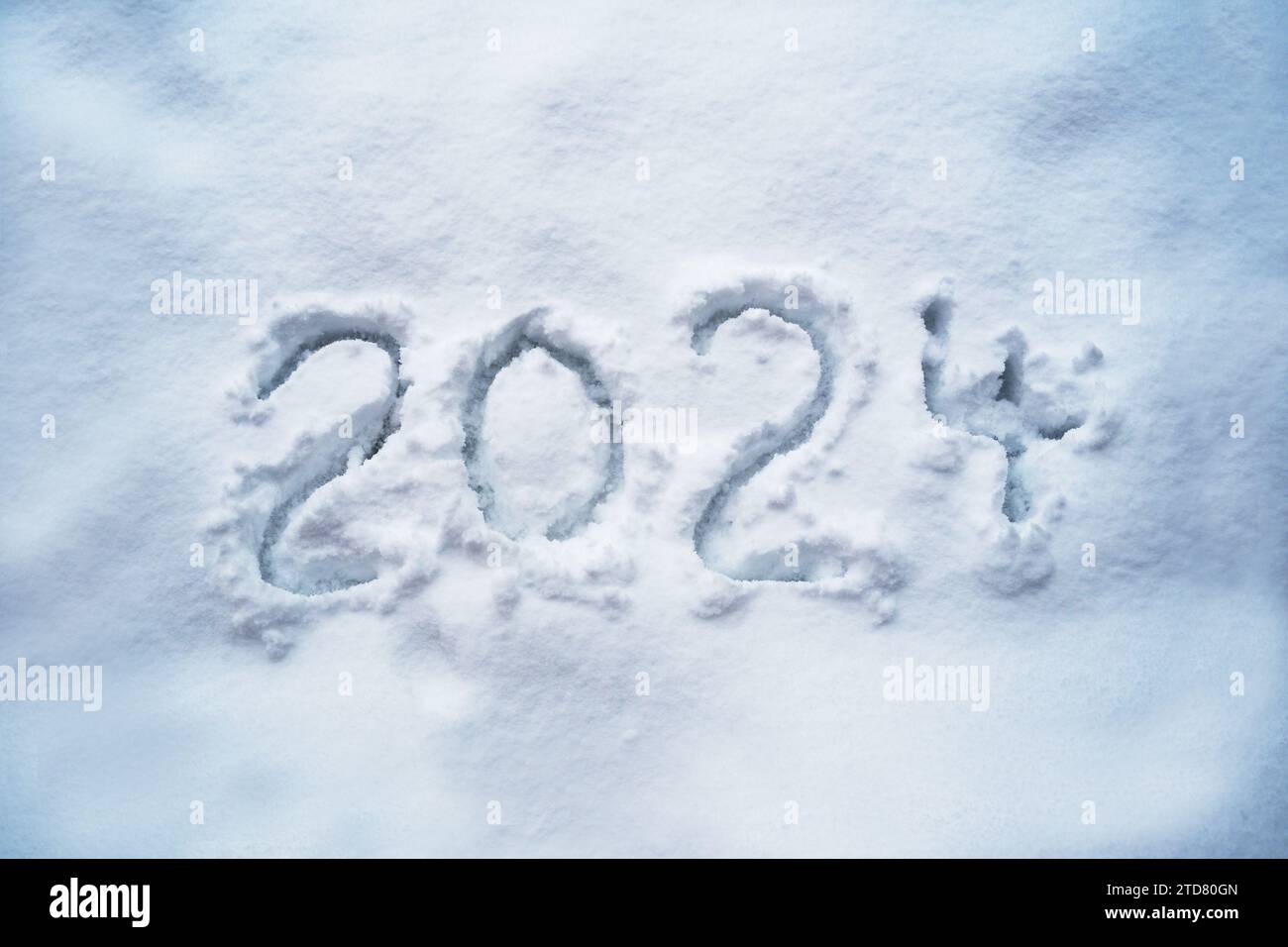 Numéro 2024 pour la nouvelle année manuscrite dans la neige, date du calendrier et symbole des fêtes, espace de copie, foyer sélectionné Banque D'Images