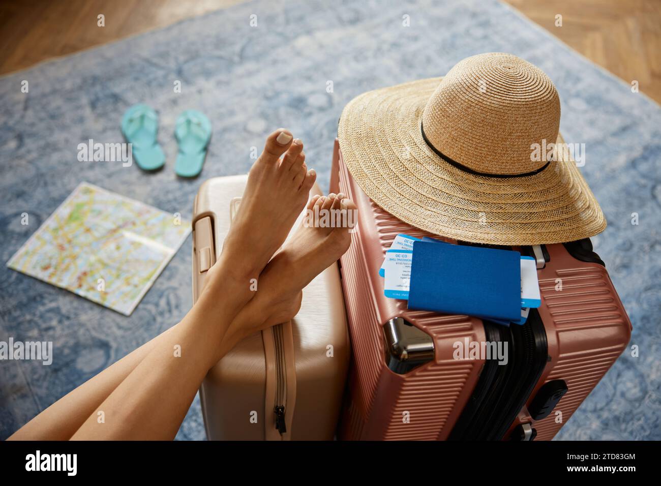 Jambes féminines élancées sur des valises à bagages de voyage avec des billets pour deux Banque D'Images