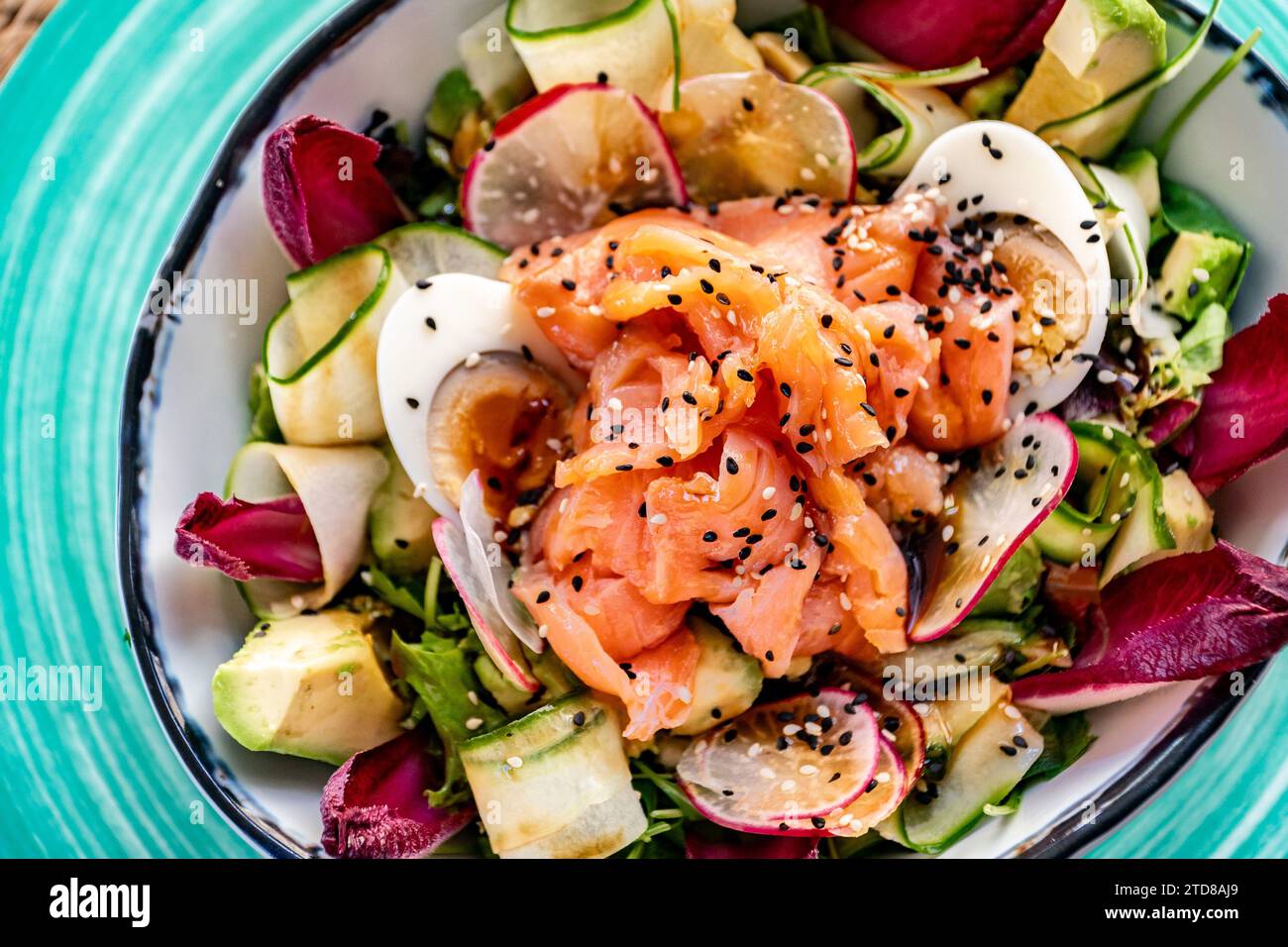 une vue d'oiseau au-dessus d'un bol de salade de légumes de saumon teriyaki fraîchement préparé. Banque D'Images