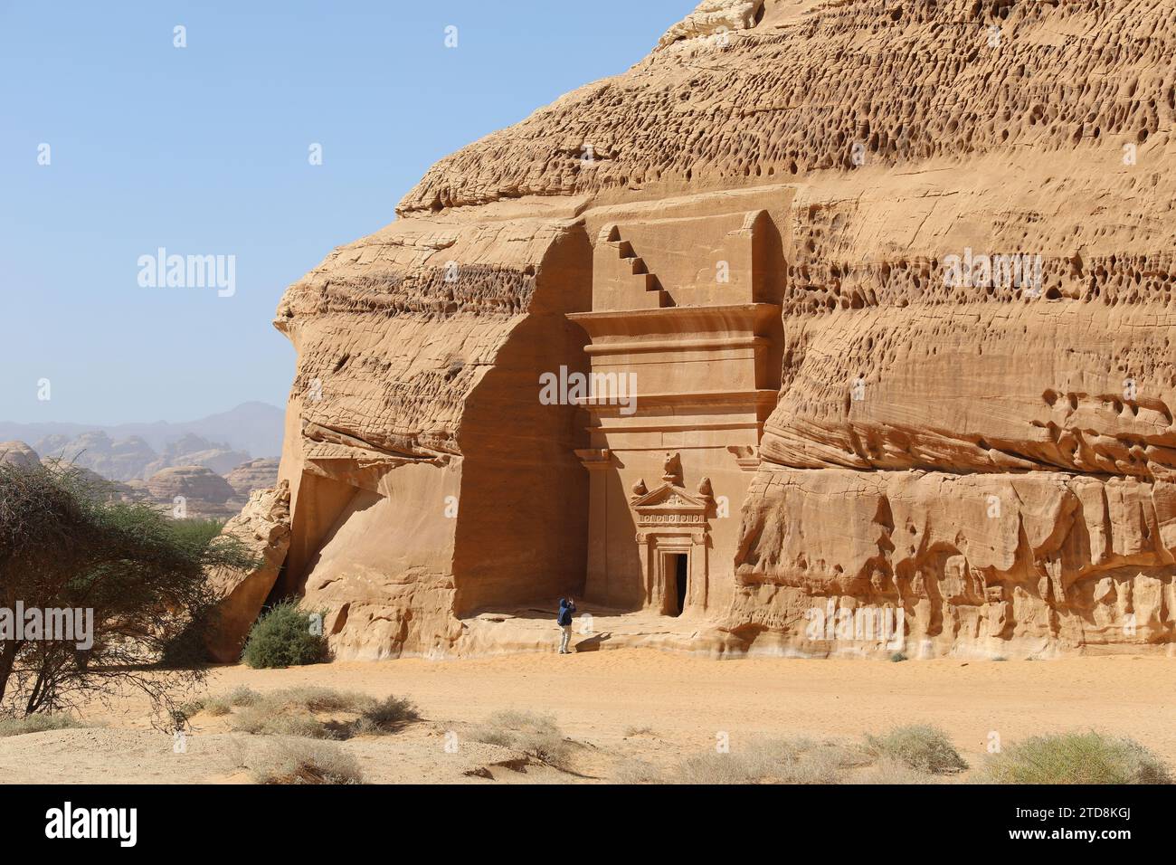 Touriste prenant une photo d'un tombeau nabatéen taillé dans la roche à Hegra en Arabie Saoudite Banque D'Images