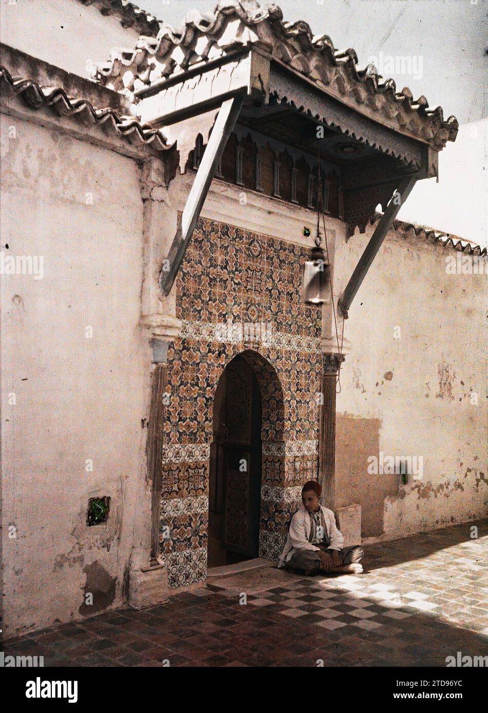 El Eubbad ou Bou Medina, Algérie Un adolescent assis à la porte de la koubba de Sidi bou Medina, personnalité, Habitat, Architecture, religion, HD, êtres humains, Art, personnalité religieuse, pèlerinage, tombeau, Architecture funéraire, Islam, existe en haute définition, enfant, Arts décoratifs, Saint, céramique, porte, architecture religieuse, à l'entrée d'une mosquée, El Eubbad, 01/01/1911 - 31/12/1911, 01/01/1910 - 31/12/1910, 01/01/1909 - 31/12/1909, Gervais-Courtellemont, Jules, 1909 ou 1910 - Algérie, Tunisie - Jules Gervais-Courtellemont et souvieux, Autochrome, photo, Glass, Autochrome, ph Banque D'Images