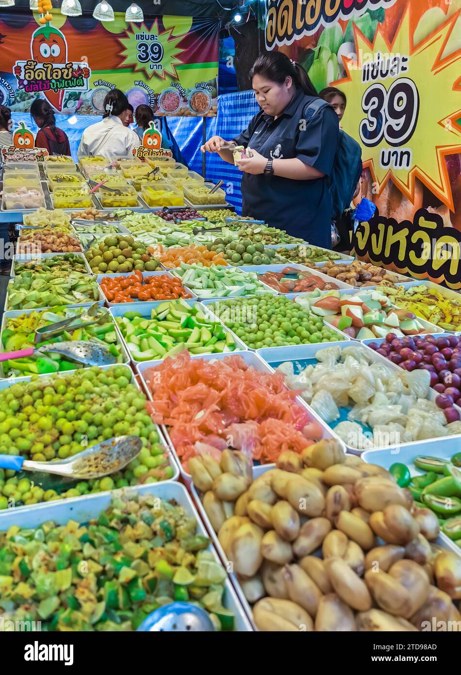 NAKHON PATHOM, THAÏLANDE - NOVEMBRE 23,2023 : les jeunes femmes non identifiées choisissent d'acheter différents types de fruits et fruits marinés, qui sont populairement ea Banque D'Images