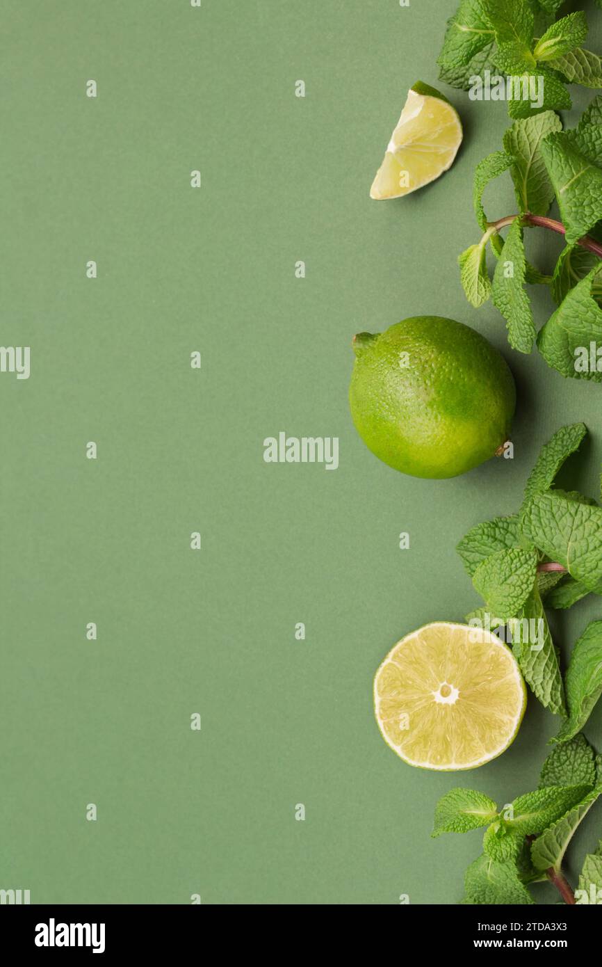 Citron vert et menthe sur fond vert. Espace de copie. Vue de dessus. Remède alternatif contre le rhume et la grippe. Banque D'Images