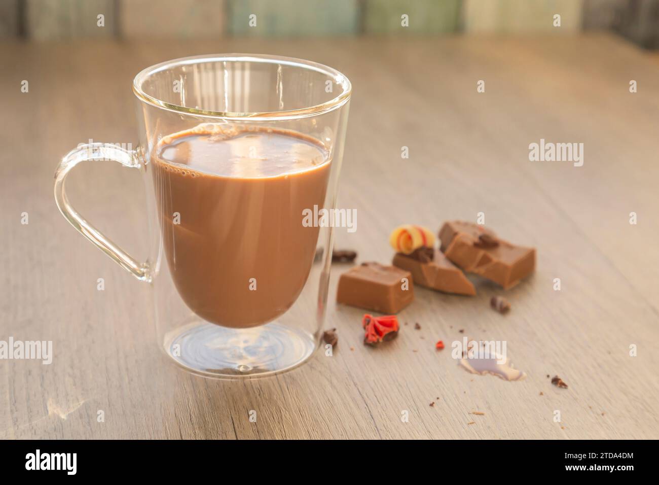 Lait au chocolat en verre et morceaux de chocolat sur table en bois Banque D'Images