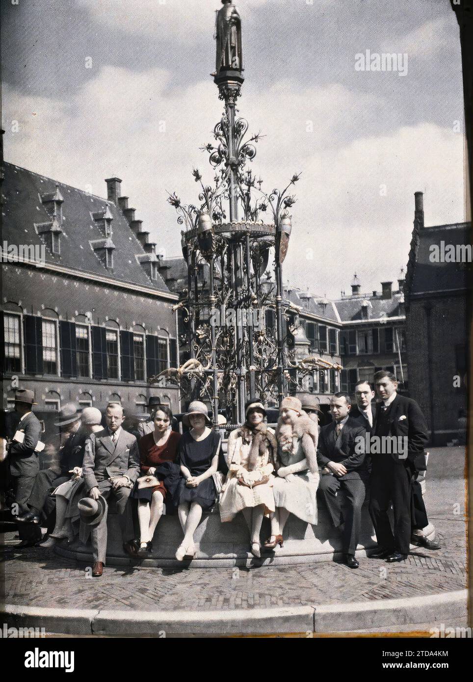 La Haye, pays-Bas Groupe de journalistes assis sur le bord de la fontaine en fer forgé, érigée par Cuyper, portant la statue du comte Guillaume II de Jünger, Art, Habitat, Architecture, êtres humains, relations internationales, Inscription, information, première Guerre mondiale, Sculpture, architecture civile publique, Portrait de Groupe, diplomatie, presse, journalisme, paix, réparations, Fontaine, ferronnerie, Cour, palais, Château, Hollande, la Haye, Binnenhof. Fontaine en fer forgé de Cuypers et statuette dorée du comte Guillaume II de Jünger, la Haye, 18/08/1929 - 18/08/1929, Passet, Stéphane, photographe Banque D'Images