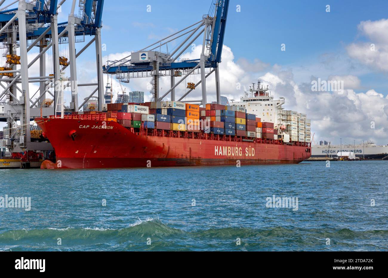 Cap Jackson Hamburg Sud porte-conteneurs le long de grues latérales sur les quais de chargement dans la ville portuaire d'Auckland, Nouvelle-Zélande Banque D'Images