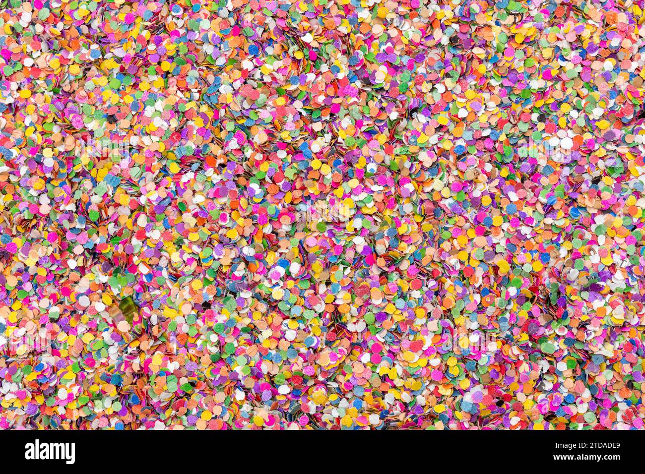 Vibrant Confetti Celebration : texture de fond de fête colorée pour les événements festifs, deux ours en gomme cachés et faisant dans un lit de confettis Banque D'Images