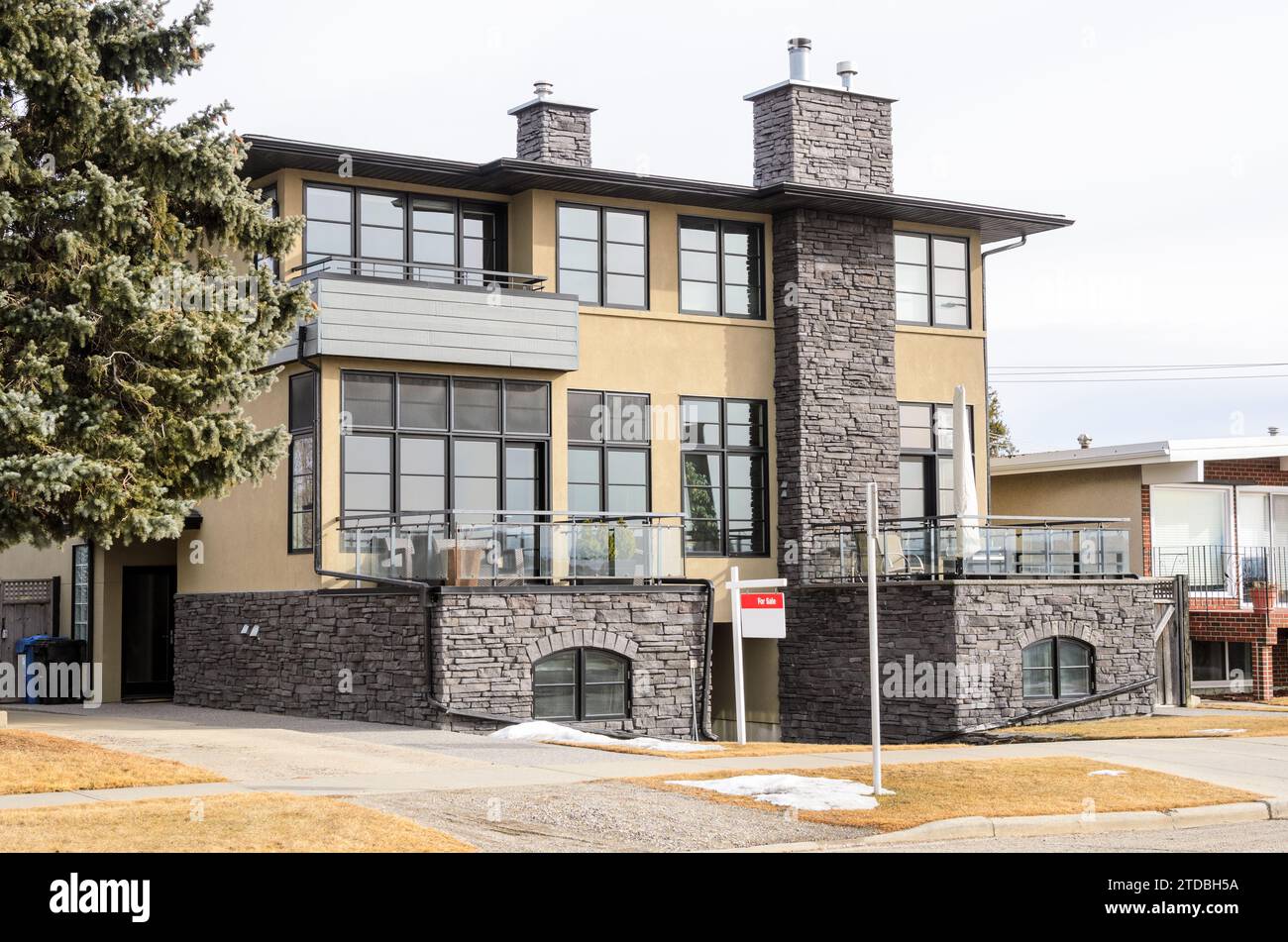 Enseigne immobilière devant une maison jumelée en vente le jour nuageux d'hiver Banque D'Images