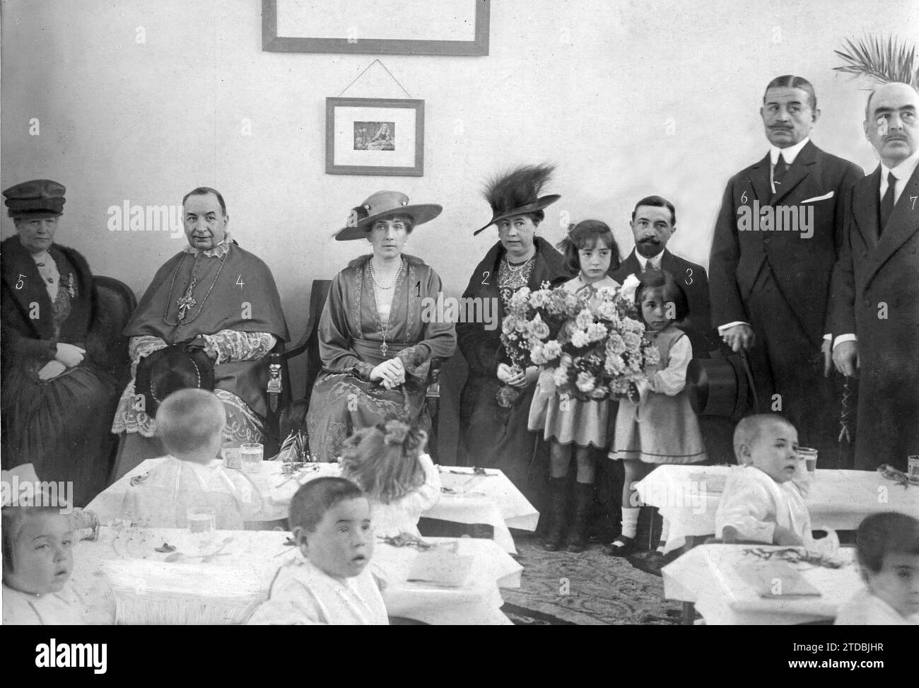 05/01/1918. Dans le groupe scolaire Reina Victoria, de Madrid. S.M. la Reine Victoria Eugenia (1), avec la fondatrice, marquise de Torrelaguna (2) ; la directrice générale de l'enseignement primaire, l'évêque du diocèse, le Dr Melo (4) ; la duchesse de San Carlos (5), le maire (6) et le gouverneur civil (7), témoin hier demain du déjeuner de 200 enfants pauvres. Crédit : Album / Archivo ABC / Ramón Alba Banque D'Images