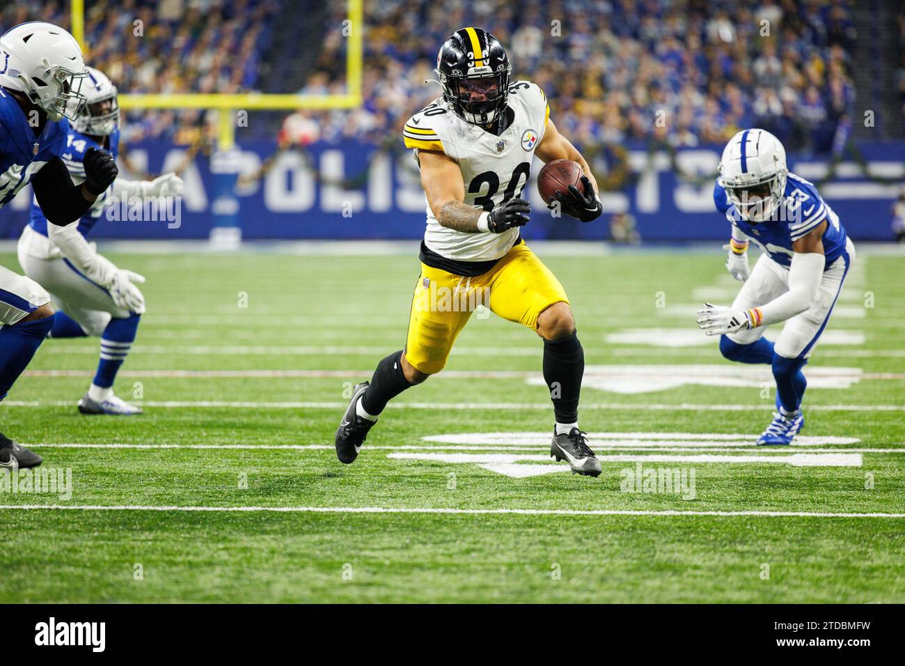 Indianapolis, Indiana, États-Unis. 16 décembre 2023. Jaylen Warren (30) court avec le ballon alors que les défenseurs des Colts d'Indianapolis poursuivent lors d'un match de football de la NFL au Lucas Oil Stadium d'Indianapolis, Indiana. Indianapolis bat Pittsburgh 30-13. John Mersits/CSM/Alamy Live News Banque D'Images