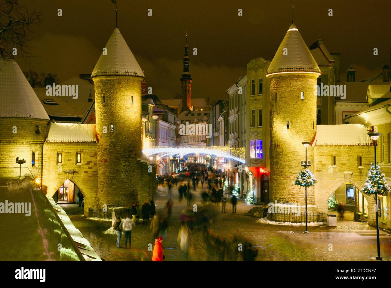 Tours en pierre de la porte Viru avec des centaines de clients et des foules festives marchant (motion blur) vers le marché de Noël dans la vieille ville de Tallinn, Estonie Banque D'Images