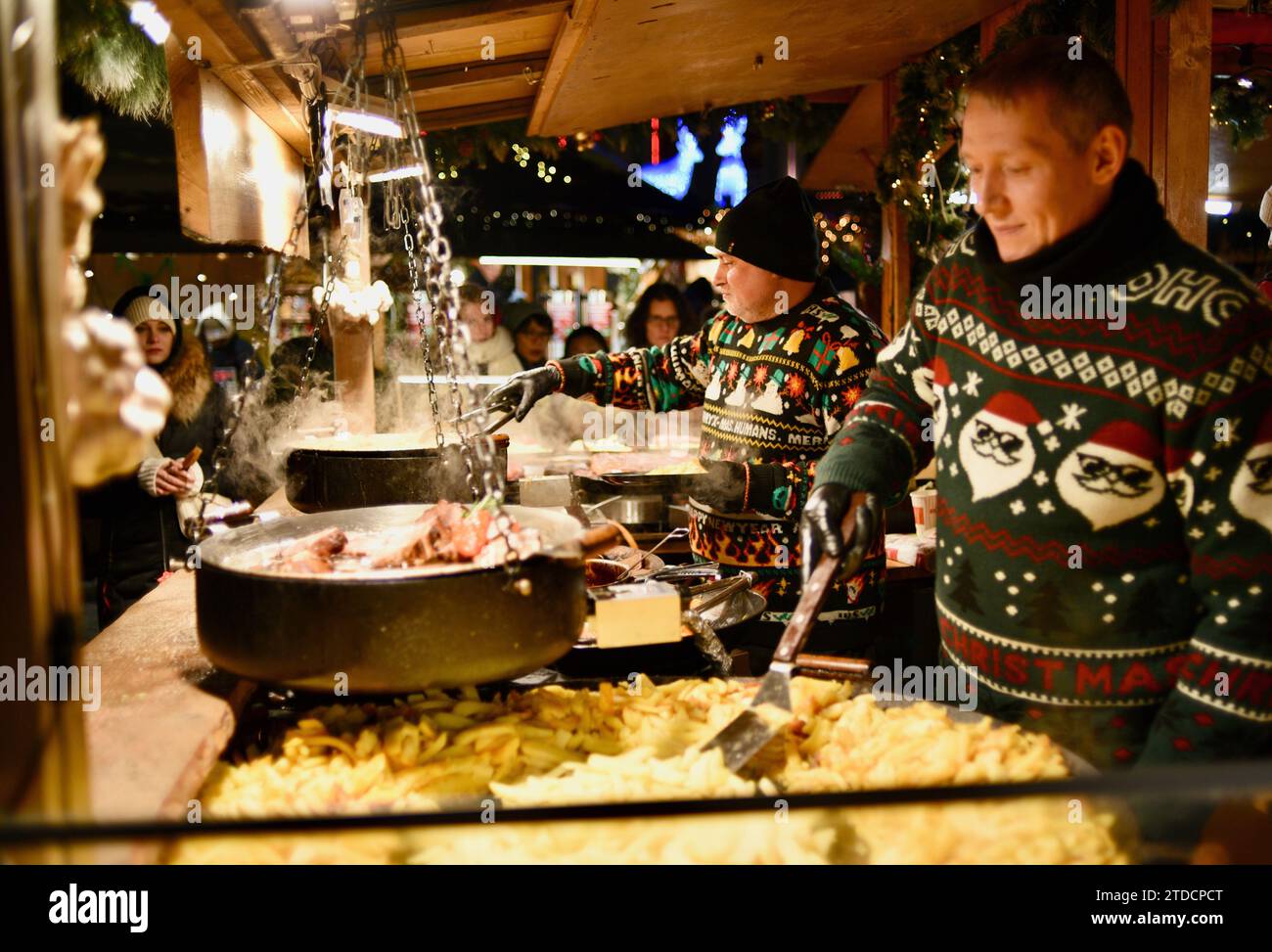 Cuisiniers préparant des saucisses et d'autres articles dans des stands de nourriture en plein air au marché de Noël de Tallinn dans la vieille ville médiévale de Tallinn, Estonie Banque D'Images