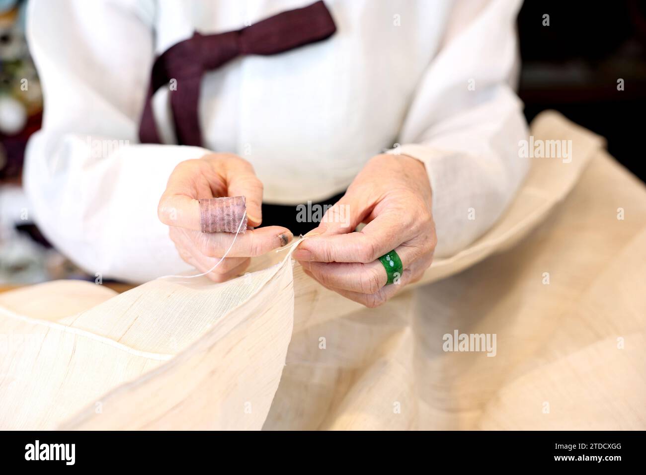 Un maître des vêtements traditionnels coréens, un expert Hanbok, est en train de coudre pour la production Hanbok. Banque D'Images