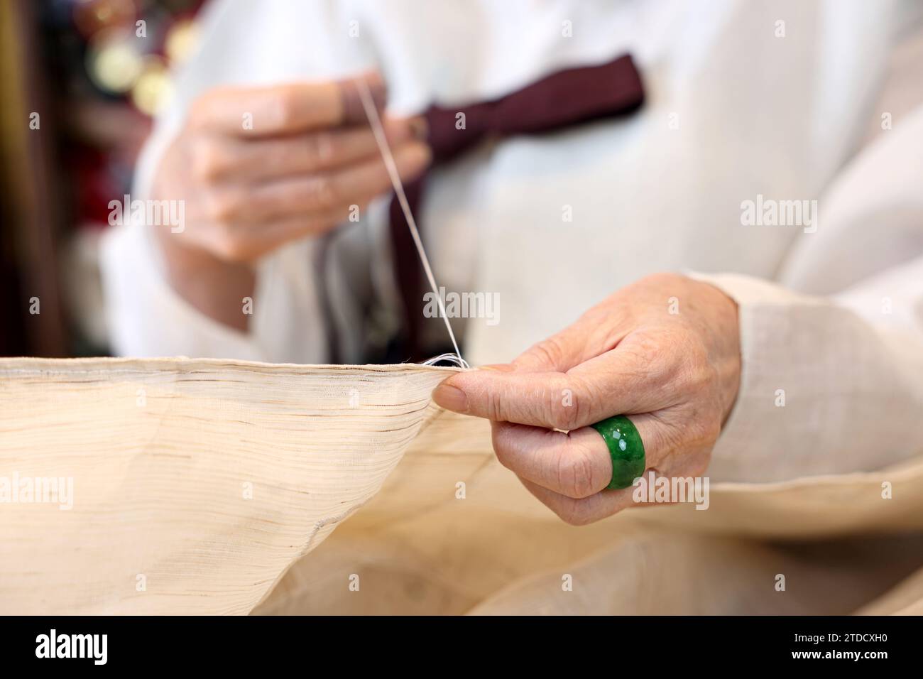 Un maître des vêtements traditionnels coréens, un expert Hanbok, est en train de coudre pour la production Hanbok. Banque D'Images