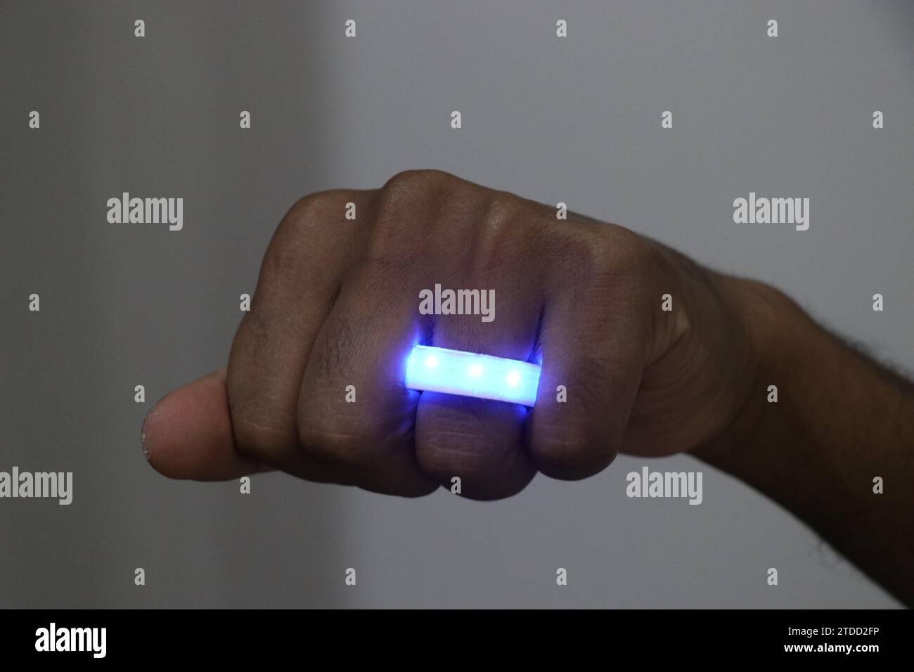 Anneau lumineux LED de couleur bleue. Porter un anneau lumineux lumineux sur le doigt Banque D'Images