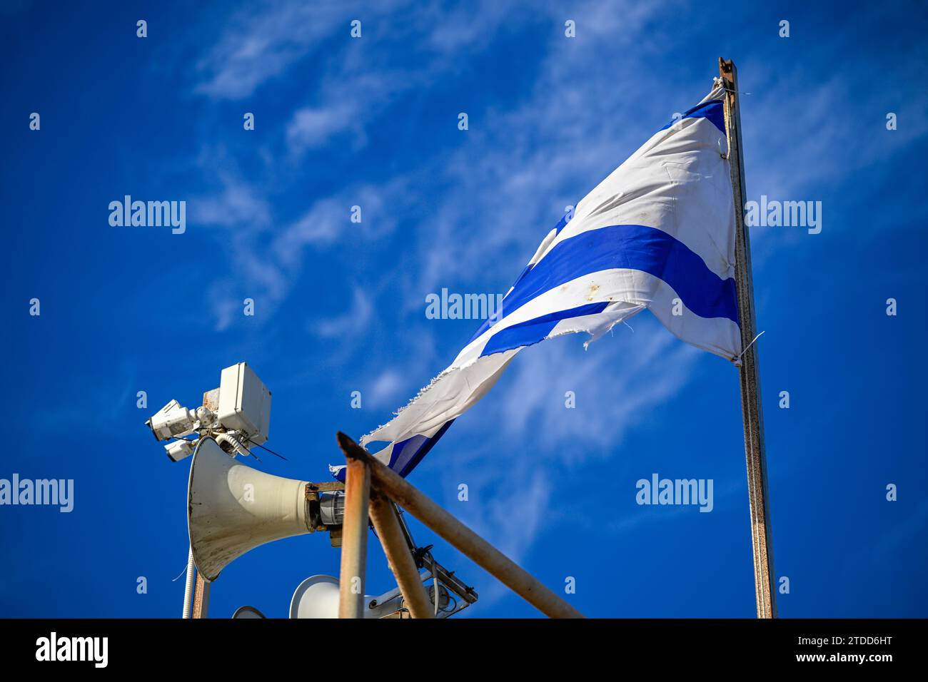 Gros plan isolé du drapeau israélien volant dans le vent avec fond de ciel bleu au coucher du soleil sur la plage en Israël Banque D'Images