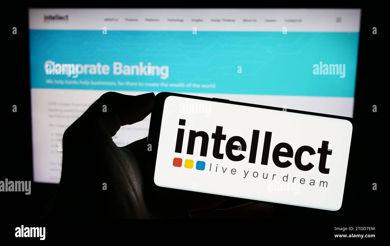 Personne tenant un téléphone portable avec le logo de la société financière indienne intellect Design Arena Ltd. Devant la page Web de l'entreprise. Concentrez-vous sur l'affichage du téléphone. Banque D'Images