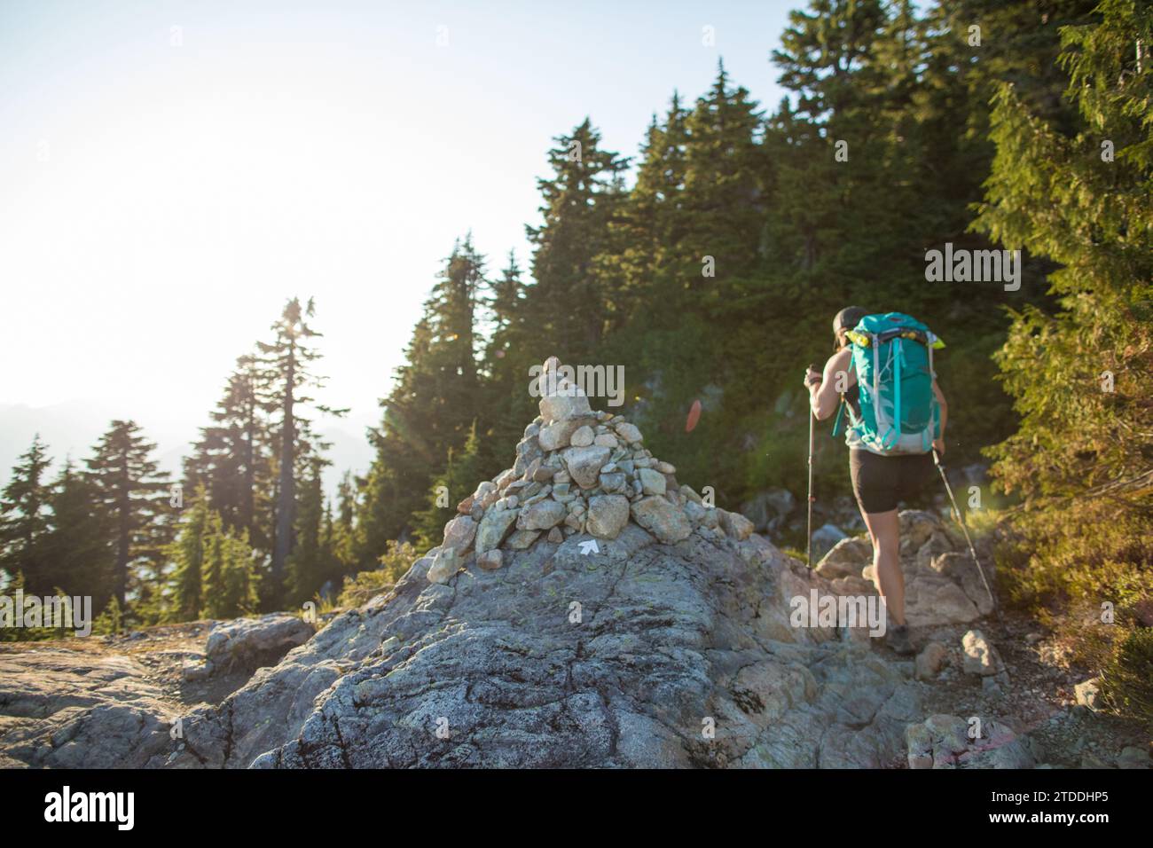 Vue arrière de la randonnée Backpacker à côté de grand cairn sur le sentier. Banque D'Images