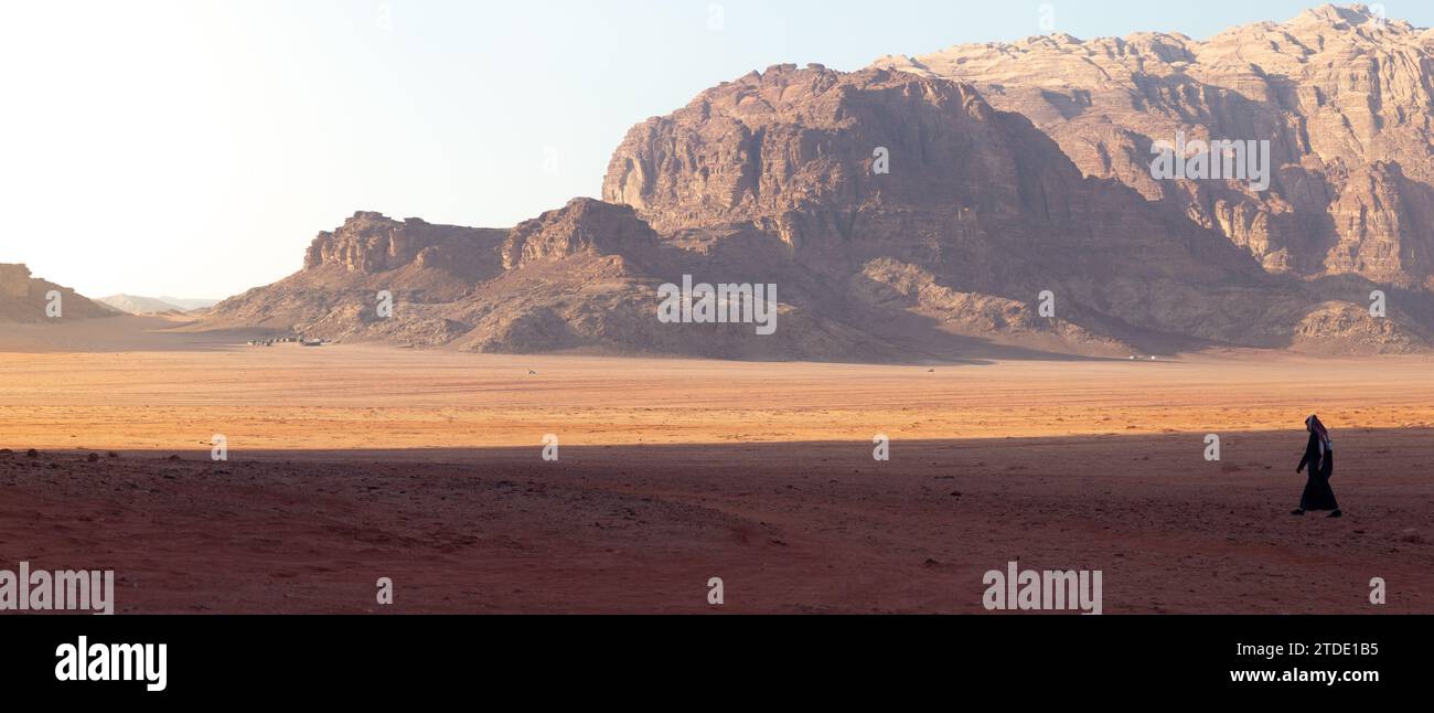 Panoramique d'un homme vêtu de noir, marchant dans le désert, Wadi Rum Banque D'Images