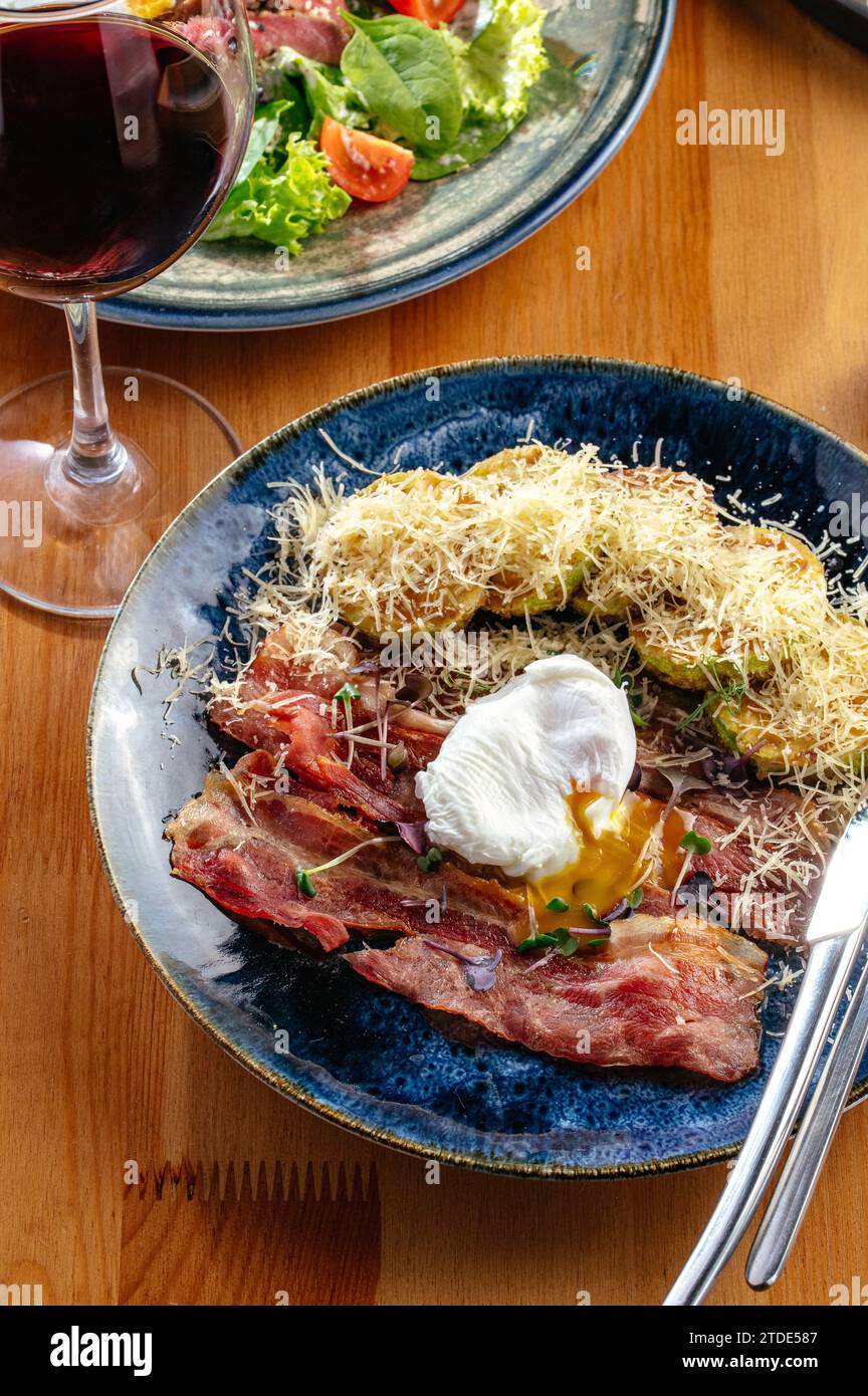 courgettes grillées, œuf poché et bacon frit Banque D'Images