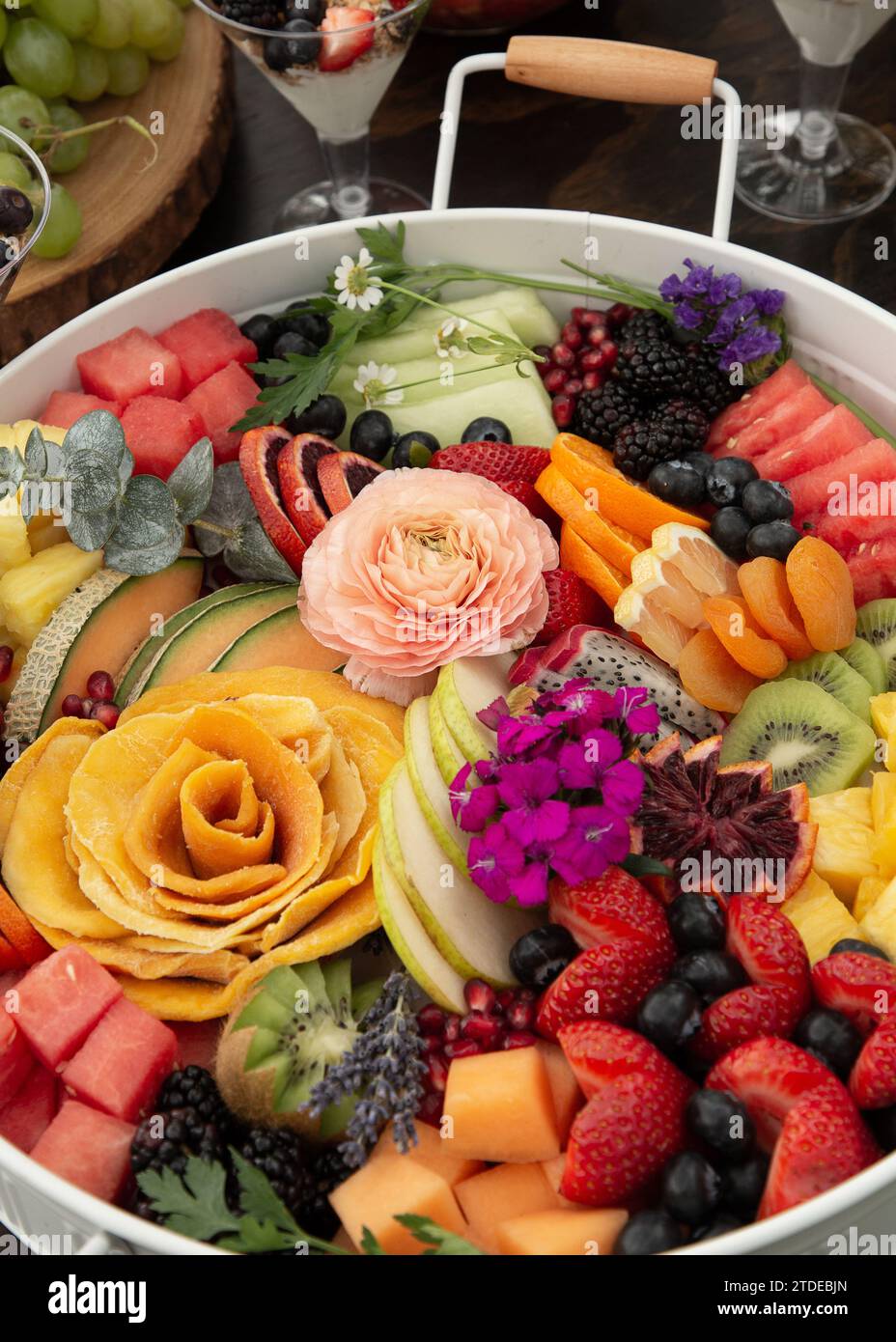 Plateau de fête de fruits tranchés avec des fleurs Banque D'Images