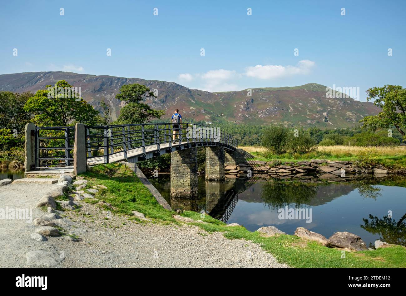 Homme marcheur sentier pédestre touristique à travers le pont chinois près de Catsbells Derwentwater en été Lake District National Park Cumbria Angleterre Royaume-Uni Banque D'Images