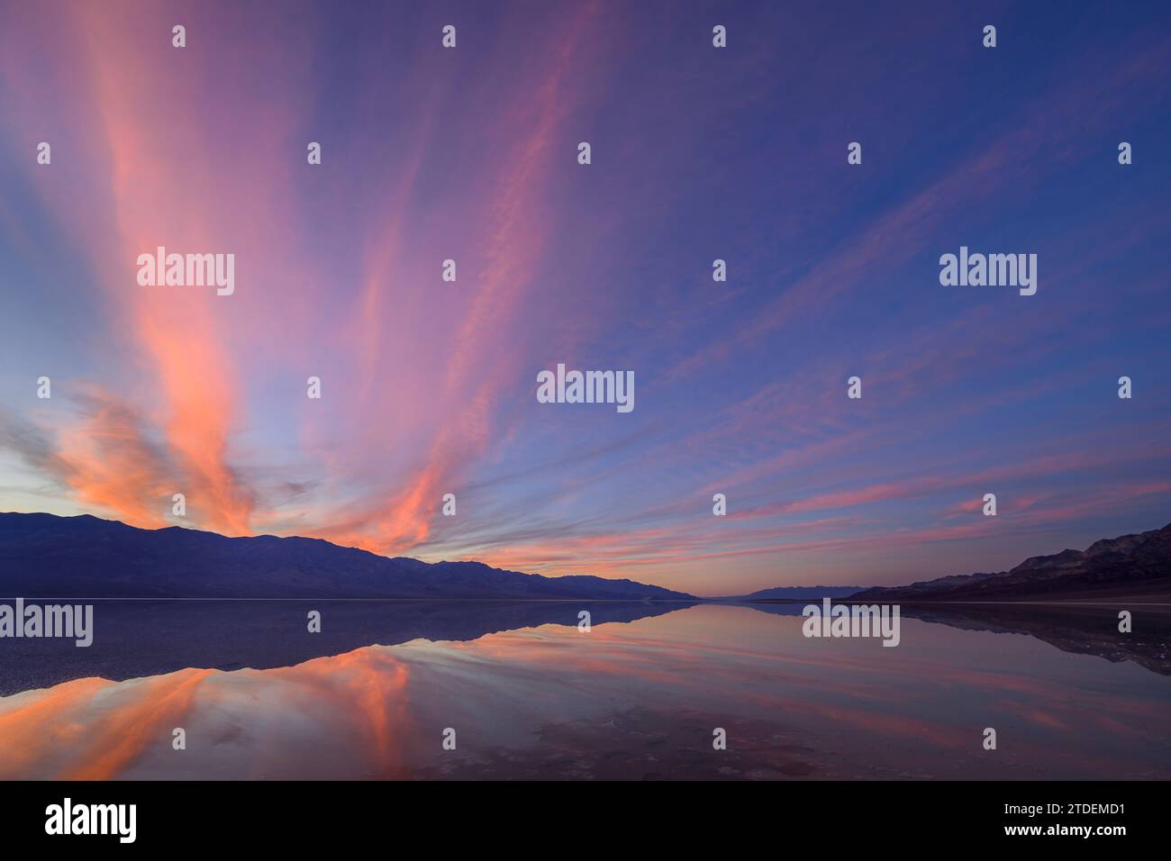 Coucher de soleil sur les montagnes Panamint avec le bassin Badwater inondé, recréant le lac Manly ; parc national de la Vallée de la mort, Californie. Banque D'Images