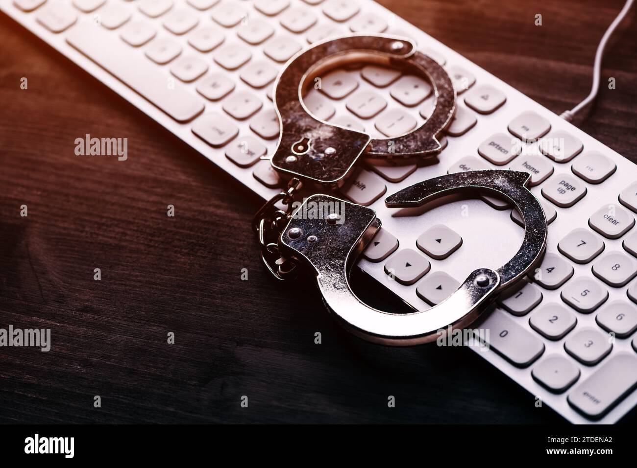 Concept d'arrestation de cybercriminalité INFORMATIQUE DE haute technologie, image de menottes de police sur le clavier d'ordinateur, focalisation sélective Banque D'Images
