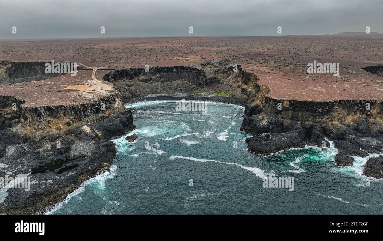 Aérien de la côte sauvage avec bassins de basalte sur la côte atlantique, Dombe Grande, Namibie, Angola, Afrique Banque D'Images