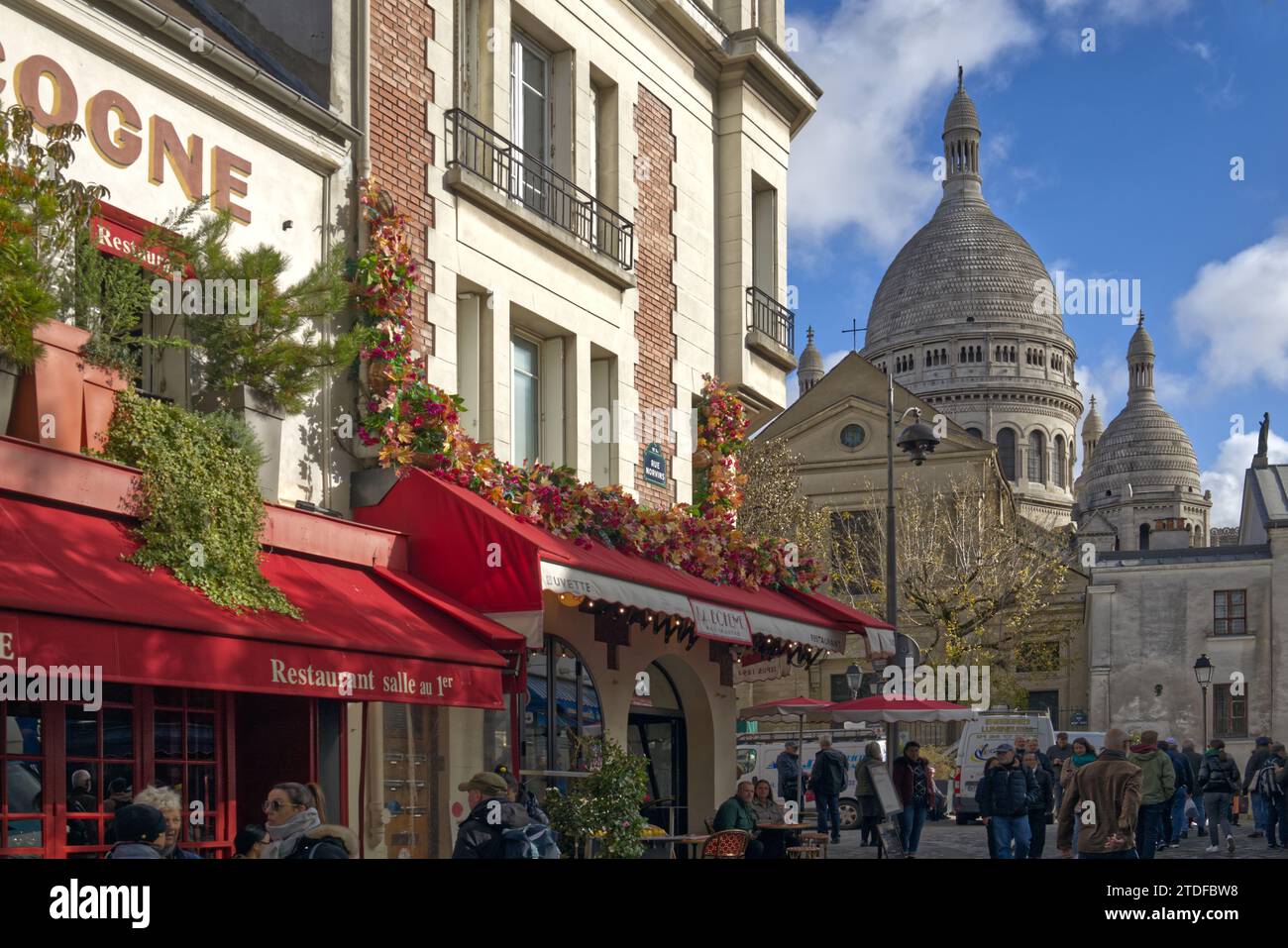 Les touristes visitent à côté des cafés de la rue Norvins surplombés par les dômes de la basilique du Sacré-cœur, Montmartre, Paris, France Banque D'Images